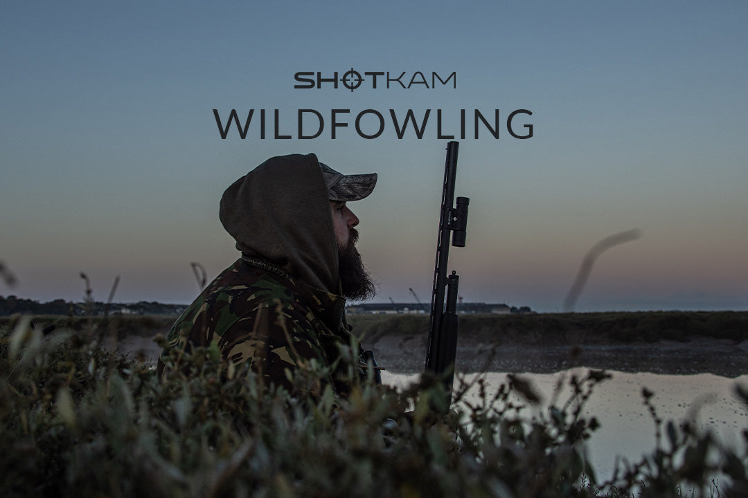 European hunter positioned by the water's edge during an early morning wildfowling session, preparing for duck hunting.