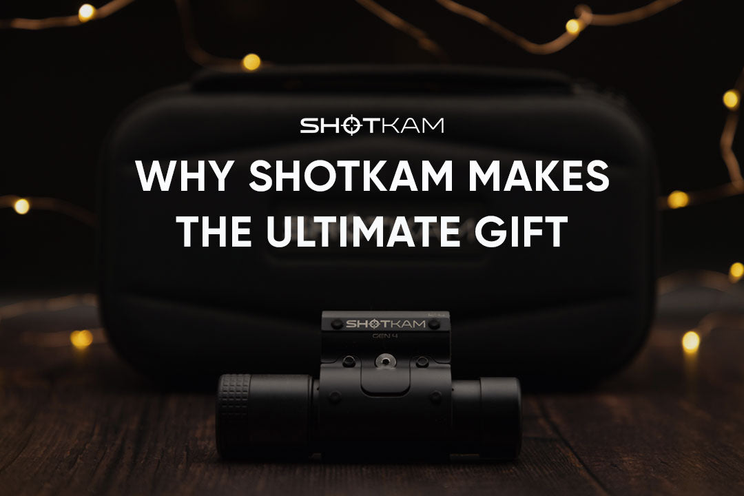 Close-up of a ShotKam barrel-mounted camera positioned on a wooden surface with festive lights behind it.